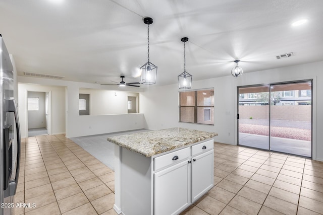 kitchen featuring light tile patterned floors, visible vents, stainless steel refrigerator with ice dispenser, and decorative light fixtures