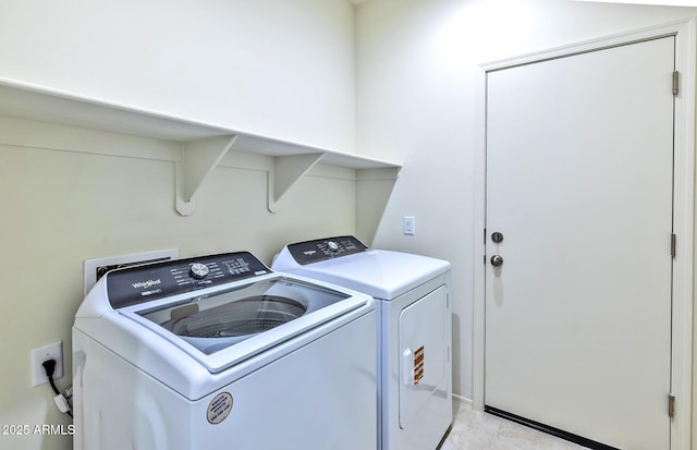 washroom featuring washer and clothes dryer, light tile patterned floors, and laundry area