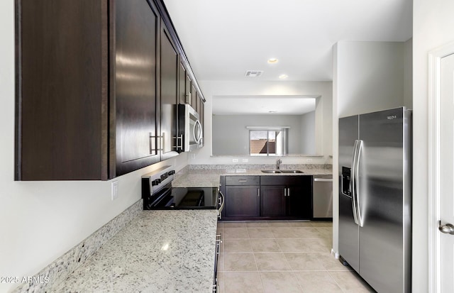 kitchen with dark brown cabinets, visible vents, light tile patterned floors, a sink, and appliances with stainless steel finishes