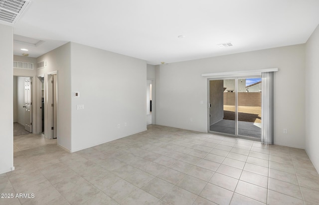 empty room with attic access, visible vents, and light tile patterned floors