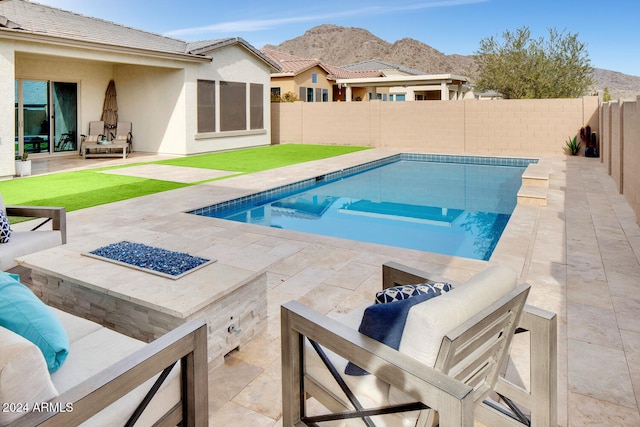 view of pool with a mountain view, a fire pit, and a patio area