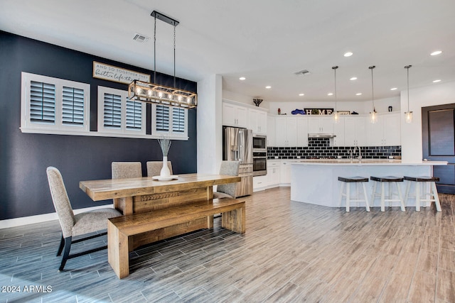 dining space featuring light hardwood / wood-style floors and sink