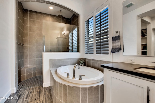 bathroom featuring vanity and independent shower and bath