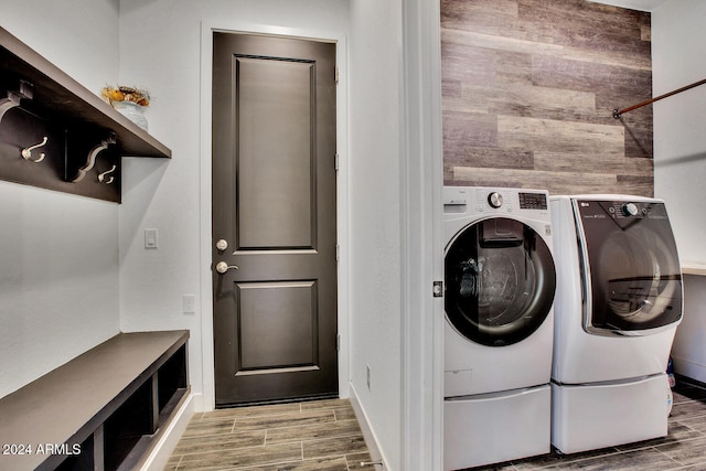 washroom featuring washer and dryer, hardwood / wood-style flooring, and wood walls