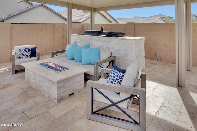 view of patio / terrace with an outdoor kitchen and a fire pit