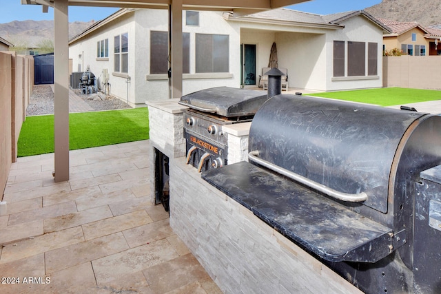 view of patio featuring a mountain view, area for grilling, and a grill