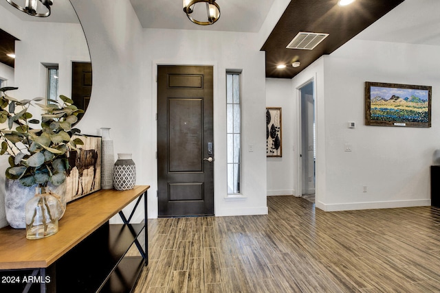 entryway with hardwood / wood-style floors and an inviting chandelier