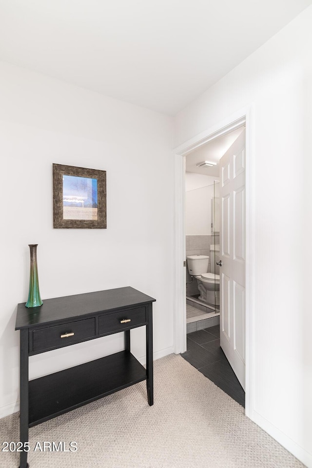 hallway featuring dark colored carpet