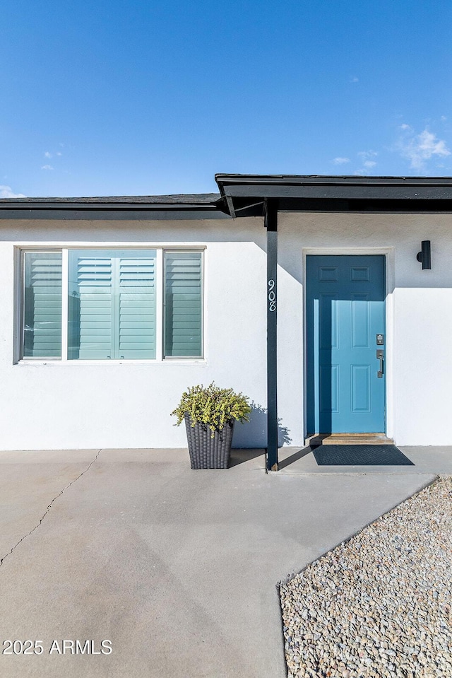 doorway to property featuring stucco siding