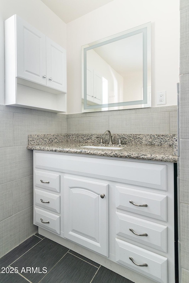 bathroom with tile patterned flooring, vanity, and backsplash