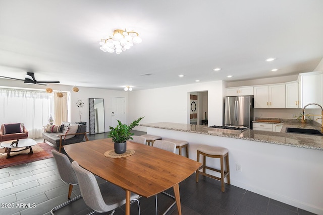 dining room featuring ceiling fan and sink