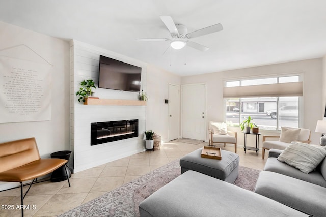 tiled living room with ceiling fan and a large fireplace