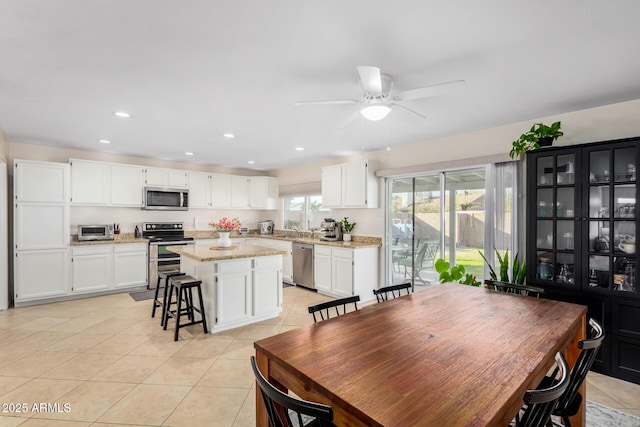 dining room with light tile patterned flooring, sink, and ceiling fan