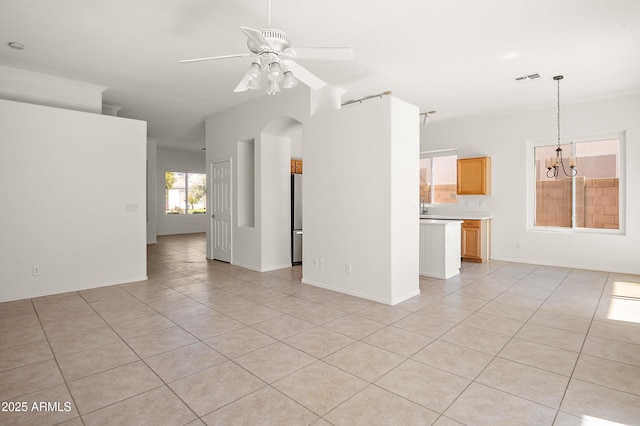 unfurnished living room with ceiling fan with notable chandelier and light tile patterned flooring