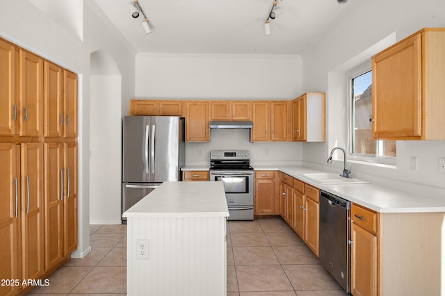 kitchen featuring rail lighting, sink, light tile patterned floors, a kitchen island, and stainless steel appliances