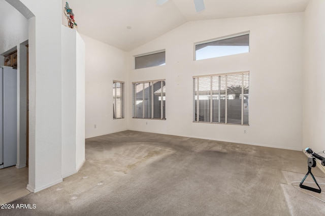 empty room featuring ceiling fan, light colored carpet, and lofted ceiling