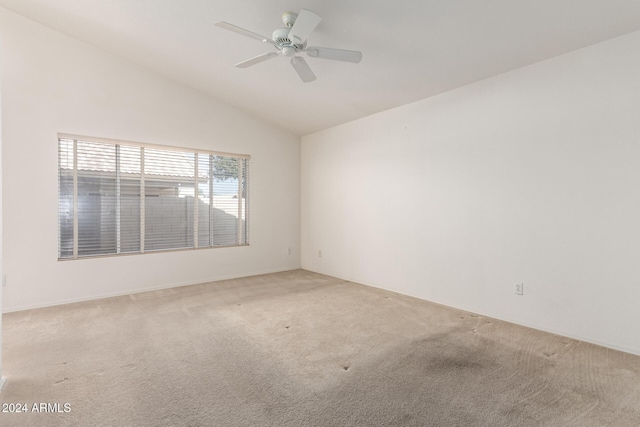 carpeted empty room featuring ceiling fan and vaulted ceiling