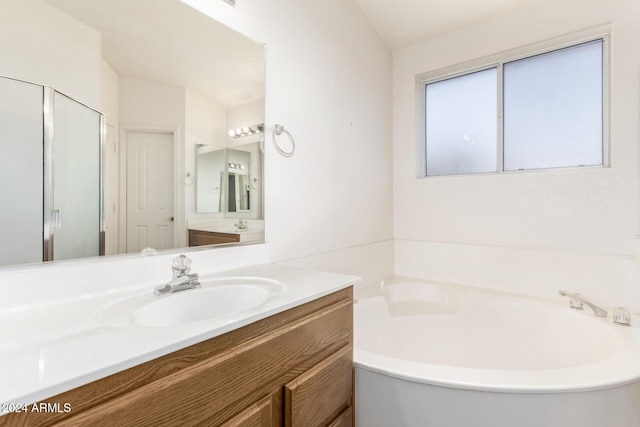 bathroom featuring vanity and independent shower and bath