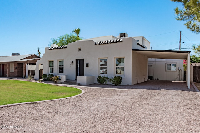 view of front facade featuring a front yard and a carport