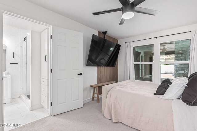 bedroom featuring light carpet, ceiling fan, and ensuite bathroom