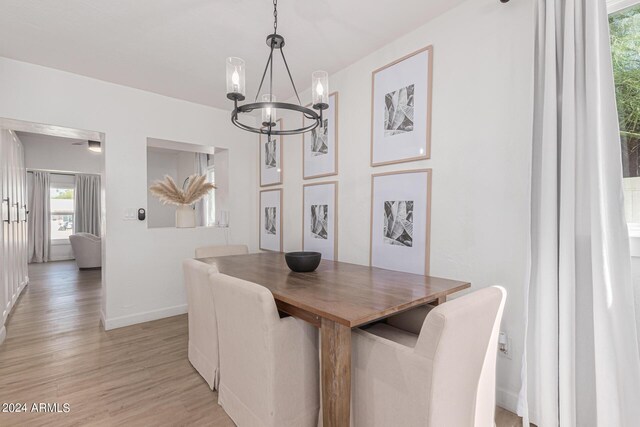 dining space featuring an inviting chandelier and light hardwood / wood-style flooring