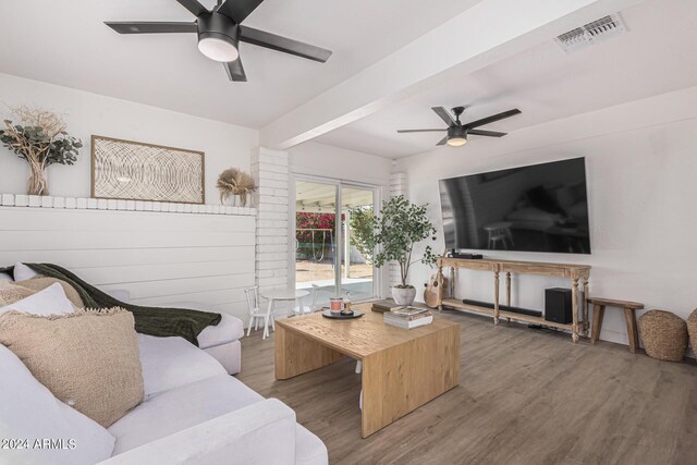 living room with beam ceiling, hardwood / wood-style floors, and ceiling fan