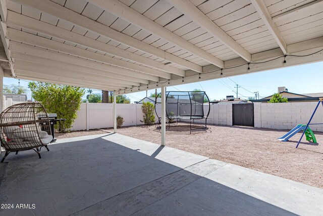 view of patio / terrace featuring a trampoline and a storage shed