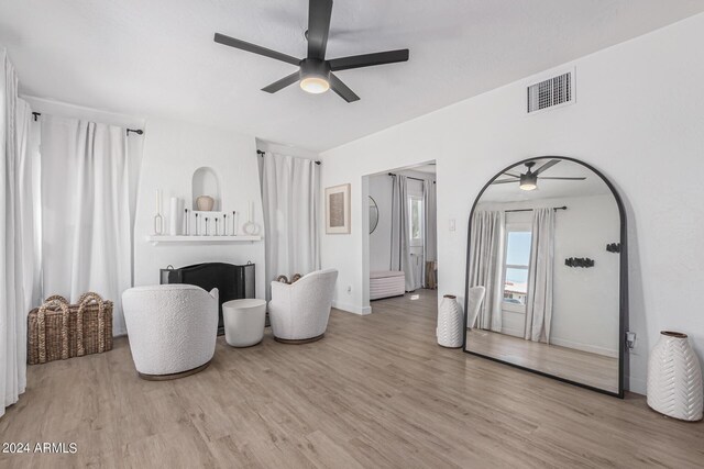 living room featuring light hardwood / wood-style floors and ceiling fan