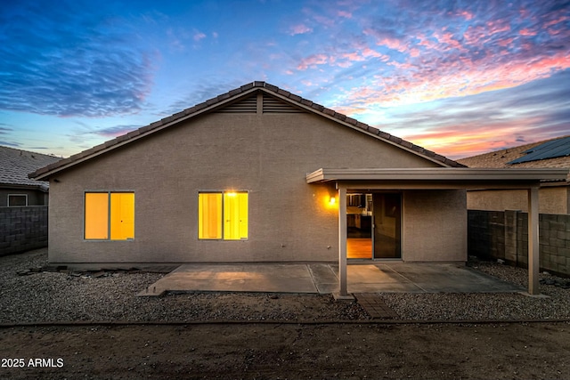 2021 E Caldwell St, Phoenix, AZ 85042 - back of house at dusk featuring stucco siding, fence, and a patio area