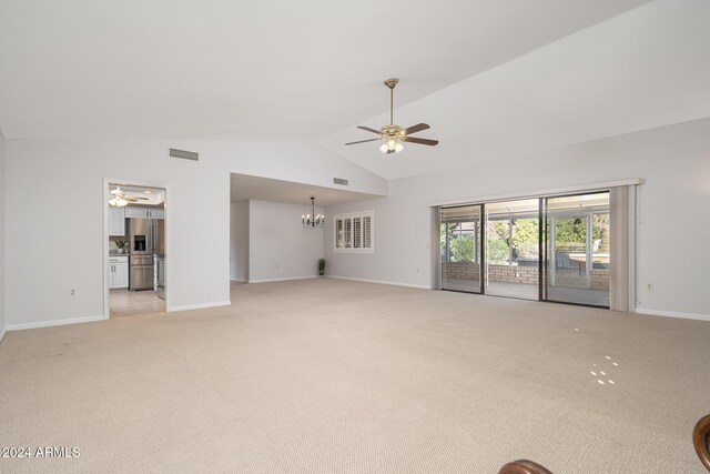 unfurnished living room featuring light carpet, ceiling fan with notable chandelier, and vaulted ceiling