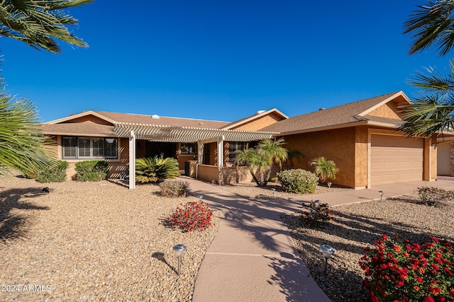 ranch-style home featuring a garage and a pergola