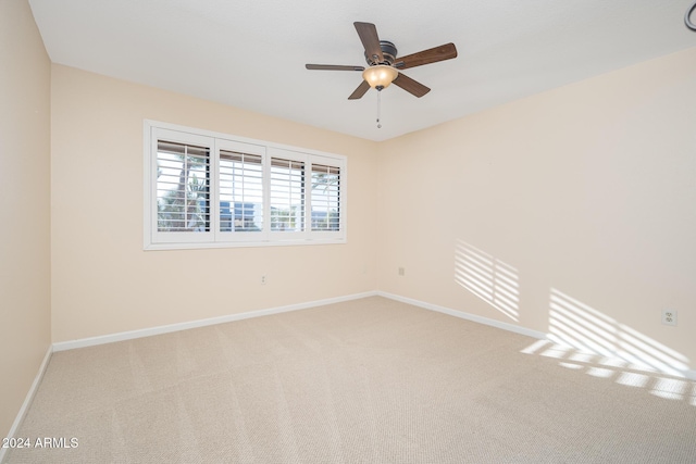 carpeted spare room with ceiling fan