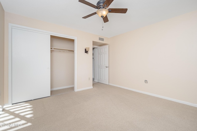 unfurnished bedroom featuring ceiling fan, light carpet, and a closet