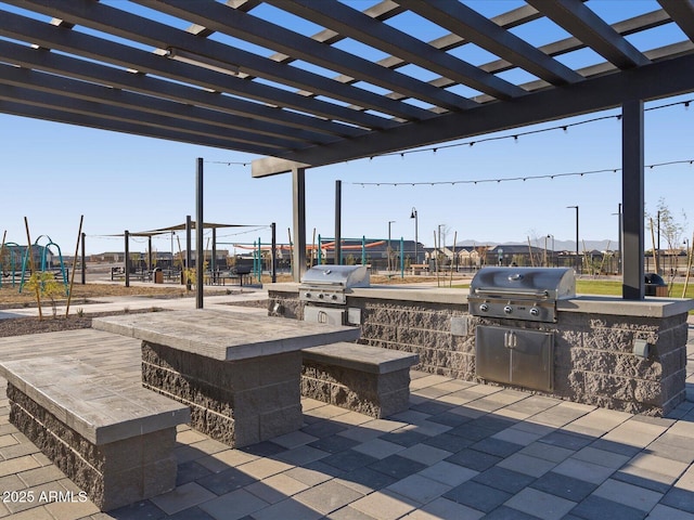 view of patio with a grill, a pergola, and exterior kitchen