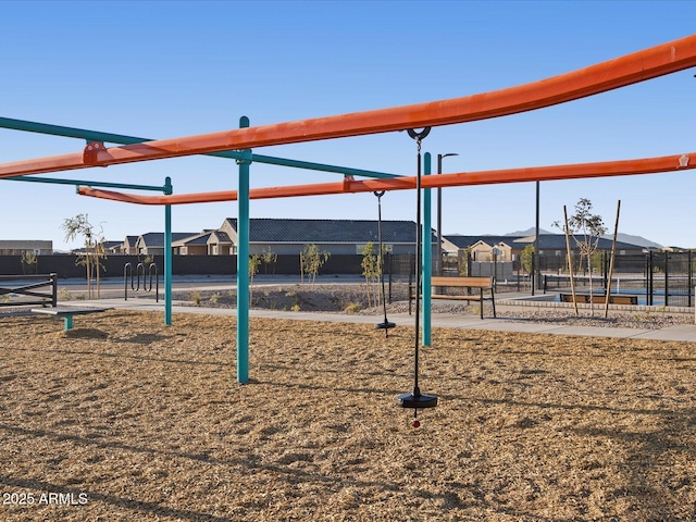 community jungle gym with a residential view and fence