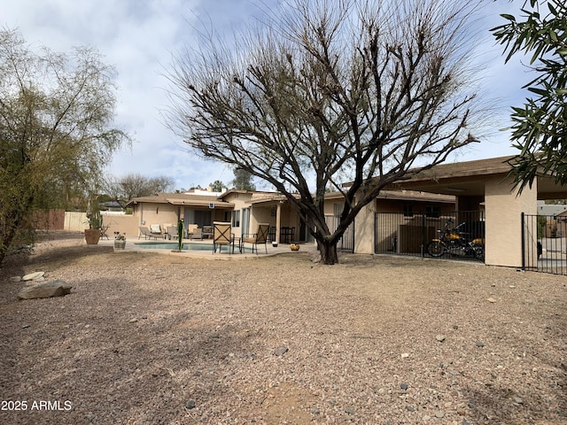 back of house with a fenced in pool and a patio area