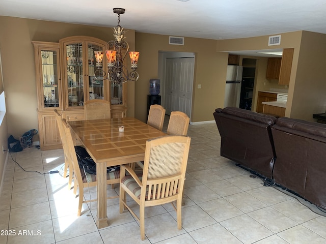 dining space featuring light tile patterned floors and a notable chandelier