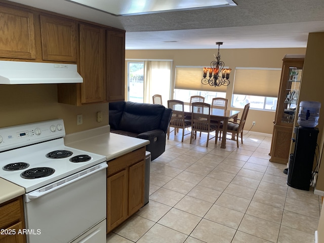 kitchen with hanging light fixtures, light tile patterned floors, a chandelier, and white electric range oven