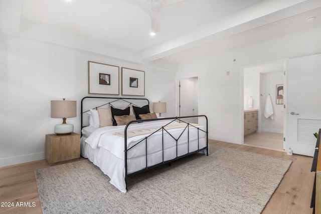 bedroom with light hardwood / wood-style floors and ensuite bath