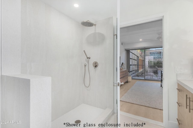 bathroom with vanity, hardwood / wood-style flooring, and tiled shower