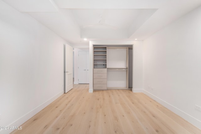 unfurnished bedroom with a closet and light hardwood / wood-style floors