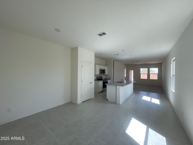 kitchen featuring white cabinets, a center island with sink, stainless steel appliances, and sink