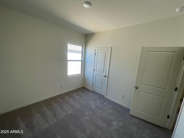 unfurnished bedroom with dark carpet