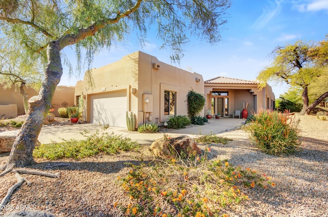 pueblo-style house featuring a garage