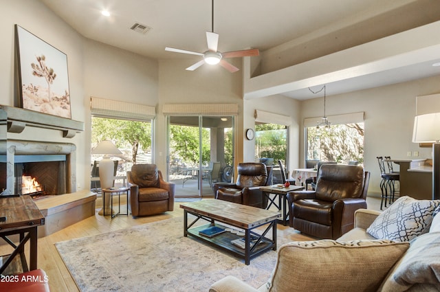 living room with ceiling fan, light wood-type flooring, and a wealth of natural light