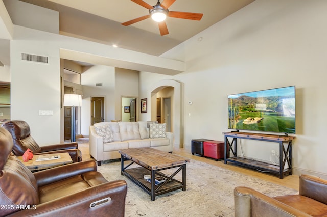 living room with light wood-type flooring, high vaulted ceiling, and ceiling fan