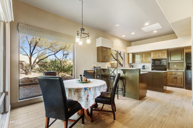 dining space with a healthy amount of sunlight and light hardwood / wood-style floors