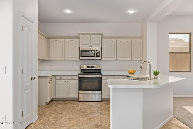 kitchen featuring sink, appliances with stainless steel finishes, cream cabinetry, and light tile patterned flooring