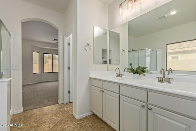 bathroom featuring vanity, tile patterned flooring, and a shower with door