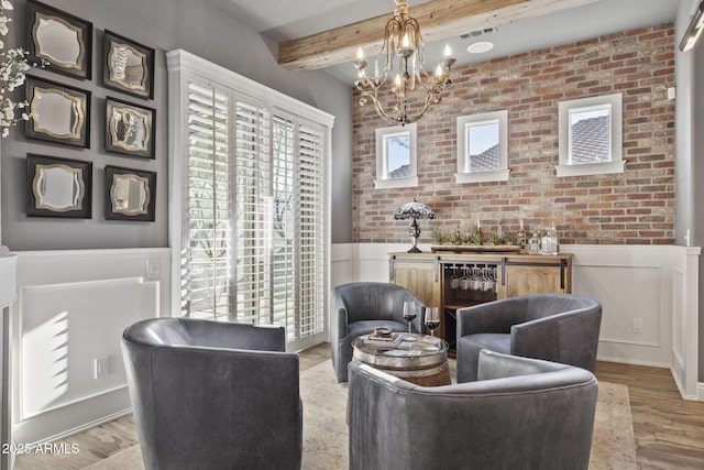 3770 E Ringtail Way, Phoenix, AZ 85050 - living area featuring wainscoting, beam ceiling, a chandelier, wood finished floors, and a decorative wall